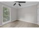 A bright bedroom with a ceiling fan, neutral walls, and a large window offering natural light at 1706 Us Hwy 70A E, Hillsborough, NC 27278