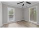 Bedroom with two windows, neutral paint, ceiling fan and wood-look vinyl flooring at 1706 Us Hwy 70A E, Hillsborough, NC 27278