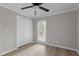 Bedroom boasts a ceiling fan, natural light from the window, closet, and contemporary floors at 1706 Us Hwy 70A E, Hillsborough, NC 27278