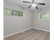 A bedroom featuring wood-look floors, two windows, and modern gray walls for a relaxing atmosphere at 1706 Us Hwy 70A E, Hillsborough, NC 27278