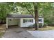 Charming one-story home featuring a carport, a light-colored brick exterior, and a well-maintained landscaped yard at 1706 Us Hwy 70A E, Hillsborough, NC 27278