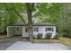 Charming one-story home featuring a carport, a light-colored brick exterior, and a well-maintained landscaped yard at 1706 Us Hwy 70A E, Hillsborough, NC 27278