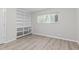 A living room featuring built-in shelving, wood-look floors, and neutral walls for a customizable space at 1706 Us Hwy 70A E, Hillsborough, NC 27278