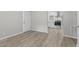 A clean living room features wood-look floors, white trim, and an open doorway leading to the kitchen at 1706 Us Hwy 70A E, Hillsborough, NC 27278