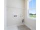 Bright laundry room featuring grey tile flooring, utility sink, and washer/dryer hookups at 1785 Birdhaven Ln, Wendell, NC 27591