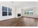 Sunlit living room showcasing dark hardwood floors, modern fireplace, large windows, and contemporary chandelier at 1785 Birdhaven Ln, Wendell, NC 27591