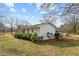Back exterior featuring a grassy lawn and lush landscape at 1837 Shamrock Dr, Burlington, NC 27215