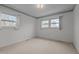 This bright bedroom features two large windows and neutral carpeting at 1837 Shamrock Dr, Burlington, NC 27215