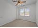 This bright bedroom features neutral carpeting, a ceiling fan, and a window with natural light at 1837 Shamrock Dr, Burlington, NC 27215