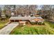 Charming brick home featuring a well-maintained lawn and mature landscaping, creating a welcoming curb appeal at 1837 Shamrock Dr, Burlington, NC 27215