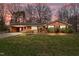 Charming brick home with a covered carport, manicured front yard, and lovely landscaping beneath the front windows at 1837 Shamrock Dr, Burlington, NC 27215
