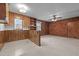 Cozy living room showing wood paneling, carpeting, and partial brick wall at 1837 Shamrock Dr, Burlington, NC 27215