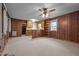 Open living room with wood paneling, carpet, and natural light from the windows at 1837 Shamrock Dr, Burlington, NC 27215