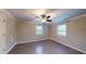 This bedroom has wood-look floors, neutral walls, a ceiling fan, and two windows at 206 Justice Heights St, Apex, NC 27502