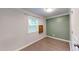 The bedroom has wood-look floors, neutral and green walls, a mounted shelf, and a window at 206 Justice Heights St, Apex, NC 27502