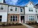 Charming townhome with stone accents, a light pink door, and manicured landscaping at 2335 Whitewing Ln, Wendell, NC 27591