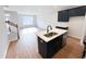 Modern kitchen with island, stainless steel appliances, and adjacent living space at 2335 Whitewing Ln, Wendell, NC 27591