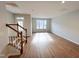 Open-concept living room with wood flooring, staircase, and lots of natural light at 2335 Whitewing Ln, Wendell, NC 27591