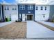 Rear exterior view of townhomes with garages, white doors and newly seeded lawns at 2335 Whitewing Ln, Wendell, NC 27591