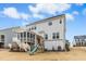 A light grey house with a backyard featuring a screened porch and a wooden play set on a brown grass lawn at 26 Stone Bridge Xing, Chapel Hill, NC 27517