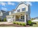 Inviting two-story home showcasing a covered porch and a two-car garage at 26 Stone Bridge Xing, Chapel Hill, NC 27517