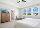 Bright main bedroom with large windows, neutral tones, ceiling fan, TV, and comfortable seating at 26 Stone Bridge Xing, Chapel Hill, NC 27517