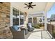 Relaxing covered porch featuring comfortable seating, a ceiling fan, and stylish stone accents at 26 Stone Bridge Xing, Chapel Hill, NC 27517