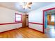 Bright bedroom with hardwood floors, red trim details, ceiling fan, and closet at 2608 Walley St, Rocky Mount, NC 27803