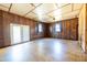 Spacious living room featuring wood paneling, two windows, and sliding glass doors to the backyard at 2608 Walley St, Rocky Mount, NC 27803