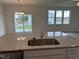 Kitchen island featuring a stainless sink, granite countertops, and an open-concept view to the backyard at 338 Tormore Dr, Homesite 123, Sanford, NC 27330
