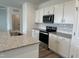 Modern kitchen featuring stainless steel appliances, white cabinets, and granite countertops at 338 Tormore Dr, Homesite 123, Sanford, NC 27330