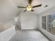 Bright bedroom with a ceiling fan and large windows showcasing the beautiful surrounding trees at 3908 Sturbridge Dr, Durham, NC 27713