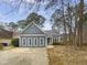 Charming single-story home featuring a blue exterior, concrete driveway, mature trees, and an inviting entrance at 3908 Sturbridge Dr, Durham, NC 27713