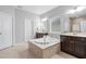 Bathroom view showcasing a soaking tub, tile flooring, and vanity with cabinetry at 3924 Overcup Oak Ln, Cary, NC 27519