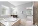Bright bathroom with tub, separate shower, vanity, and view into bedroom at 3924 Overcup Oak Ln, Cary, NC 27519