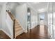 Inviting foyer featuring gleaming hardwood floors, elegant wainscoting, and a carpeted staircase at 3924 Overcup Oak Ln, Cary, NC 27519