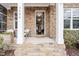 A porch with stone steps and a stone exterior, a seating area, decorative foliage, and an open front door at 3924 Overcup Oak Ln, Cary, NC 27519