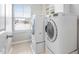 Bright laundry room with a front-load washer and dryer, shelving, and natural light from a window at 3924 Overcup Oak Ln, Cary, NC 27519