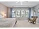 Tranquil primary bedroom with large windows, custom curtains, and an elegant chair at 3924 Overcup Oak Ln, Cary, NC 27519