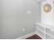 A mudroom with white storage racks, bench, hooks and a hat hanging on the wall, with hardwood flooring at 3924 Overcup Oak Ln, Cary, NC 27519