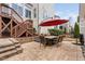 Backyard patio with brick pavers, a dining table set, an umbrella, and stone retaining wall with stairs at 3924 Overcup Oak Ln, Cary, NC 27519