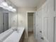 Bathroom featuring double sinks with a large mirror, tiled floor, and shower in background at 4 Strowd Ct, Durham, NC 27703