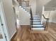 A spacious home foyer featuring hardwood floors and a staircase with a wrought iron railing at 4 Strowd Ct, Durham, NC 27703