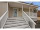 Inviting covered front porch with white railings and steps leading to a blue front door at 408 Charlotte Ave, Sanford, NC 27330
