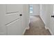 Bright hallway with neutral carpet leading to bedroom with window view at 408 Charlotte Ave, Sanford, NC 27330
