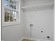 Laundry room area with white walls, new plumbing fixtures, and backyard view at 408 Charlotte Ave, Sanford, NC 27330