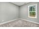 Bedroom with neutral carpet and paint, white trim and one window letting in light at 507 W Edwards St, Princeton, NC 27569