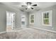 Spacious bedroom with neutral carpet, two windows letting in light, and an adjoining closet and bathroom at 507 W Edwards St, Princeton, NC 27569
