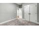 Bedroom with neutral carpet, and two white doors with black hardware, offering a clean and modern look at 507 W Edwards St, Princeton, NC 27569