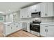 Well-equipped kitchen boasting stainless steel appliances, white cabinets, and elegant quartz countertops at 507 W Edwards St, Princeton, NC 27569